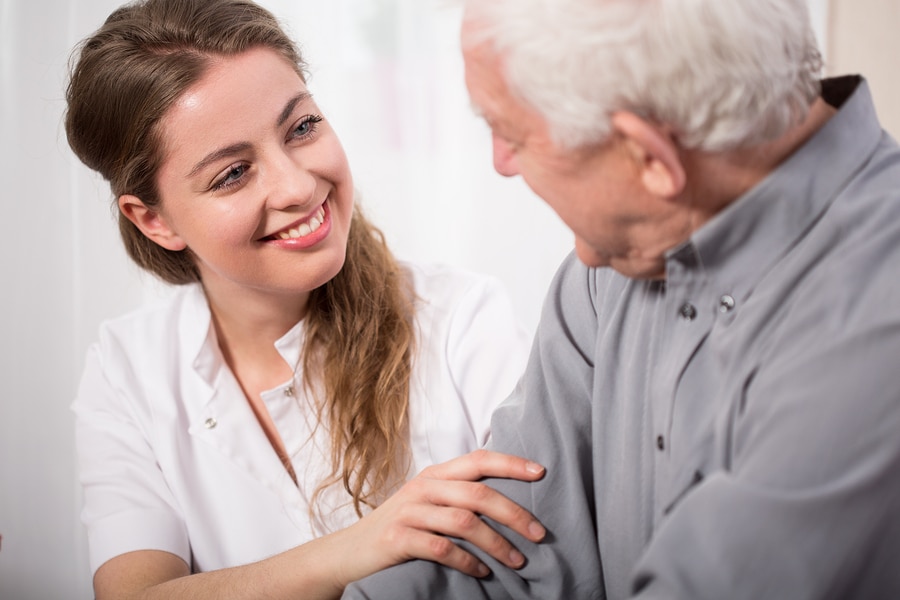 Smiling Nurse Assisting Senior Man Picture of smiling nurse assisting senior man